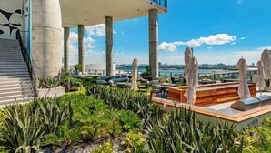 A rooftop terrace with a view of the city, featuring a pool, lounge chairs, and a modern building in the background. - Modern 3BR Oasis in Downtown Miami #1617 (Miami)