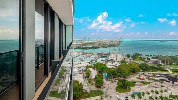 A high-rise building with a balcony overlooking a marina and a coastal cityscape. - Modern 3BR Oasis in Downtown Miami #1617 (Miami)
