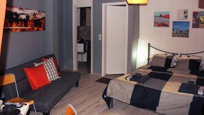 Une chambre d’hôtel comprenant un lit, un canapé, un coin repas et une cuisine.