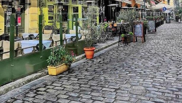 A cobblestone street lined with historic buildings, outdoor seating, and potted plants. - Apartment Sleeps 2 Free Street Parking (Thessaloniki)
