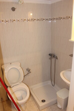 A bathroom with a toilet, shower, and sink. - Studio Sleeps 2 With Free Parking (Thessaloniki)