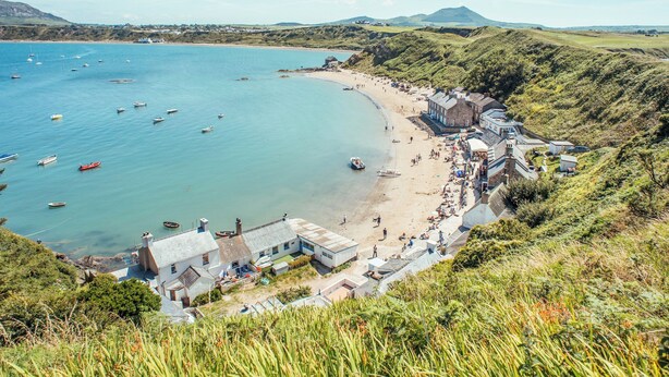 Une ville côtière avec une plage, des bateaux et des maisons.