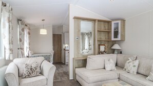Un salon confortable avec un canapé, une table basse et un coin repas comprenant une table et des chaises.