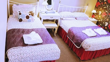 Habitación de hotel con dos camas, un tocador con espejo y un escritorio.