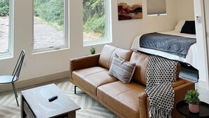 Une chambre à coucher moderne avec un lit, un ventilateur de plafond et de grandes fenêtres.
