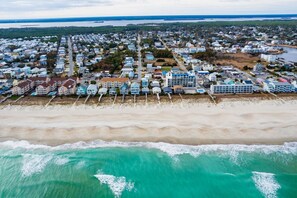 An aerial view of a coastal residential area with houses along the beach and a large body of water in the background. - Beachside Escape! King Beds, Backyard & Amenities (Carolina Beach)