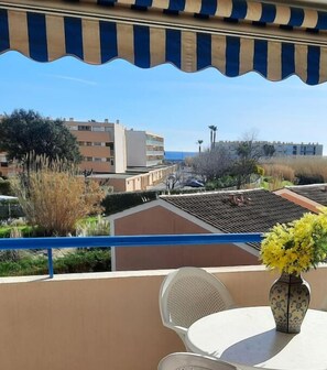 Un balcone con vista su una zona costiera, che include edifici e vegetazione.
