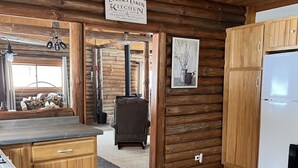 Una cocina rústica con armarios de madera, un refrigerador y un letrero que indica que es cocina.