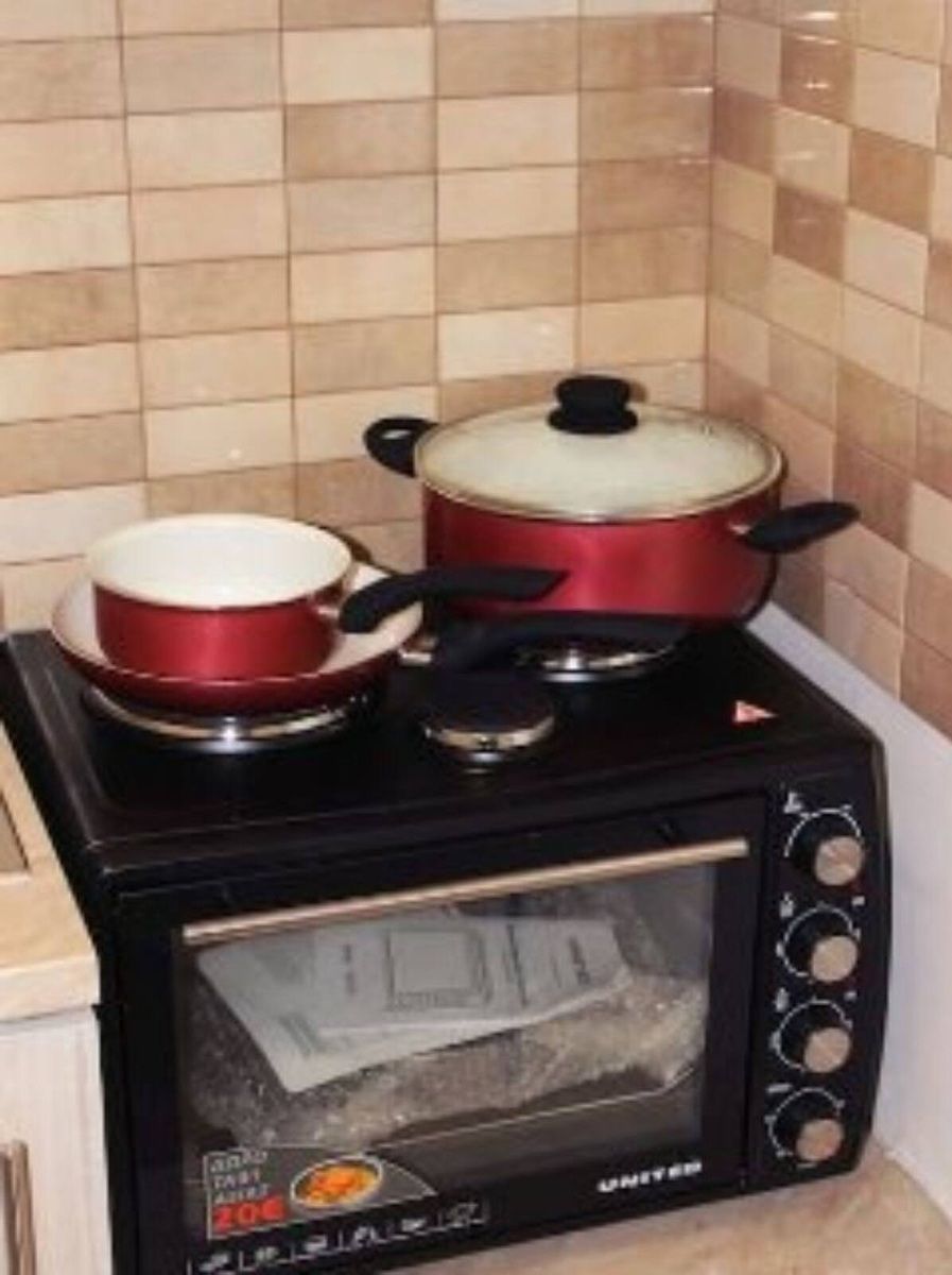 A kitchen with a black stove top oven and a microwave.