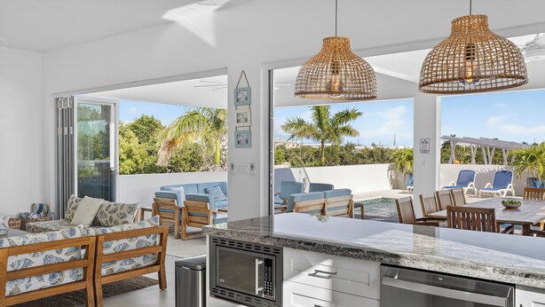 Una cocina moderna con microondas integrado, armarios blancos y una isla grande.