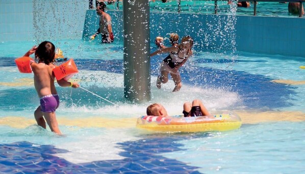 A water park with a pool, water slides, and inflatable rafts.