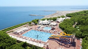 An aerial view of a resort with a large swimming pool, water slides, and a beach area. - Isaresidence Studio with pool/sea view for 4 persons (Isolaverde di Chioggia)