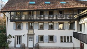 A two-story building with a balcony, multiple windows, and a door. - domaine du deven (Bourg-en-Lavaux)