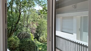 A window with a view of a garden and a white fence. - domaine du deven (Bourg-en-Lavaux)