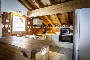 A kitchen with wooden beams, a tiled backsplash, and modern appliances. - Chalet, 300m from resort center, balcony, tv, 236m², La Plagne (La Plagne)