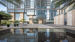 A modern building with a reflective pool in front. - Vinhomes Central Park Riverside Elegance (Ho Chi Minh City)