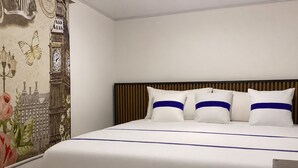 A hotel room with a bed, a headboard, and a wall with a cityscape mural. - Paramount Hotel (Bogotá)