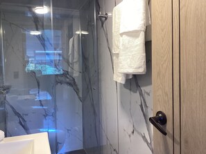 Shower, rainfall showerhead, towels, soap - Paramount Hotel (Bogotá)