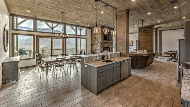 A spacious kitchen with large windows, a wooden ceiling, and a central island. - Heated pool & hot tub at huge mountain retreat

 (Cherry Log)