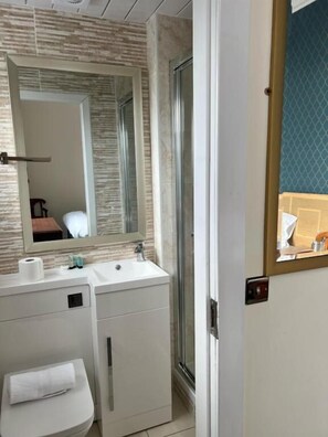 A modern bathroom with a vanity, sink, mirror, and shower. - Earl David Hotel (Kirkcaldy)