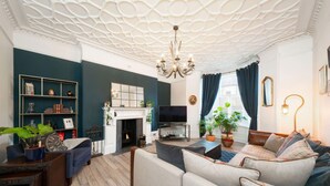 A modern living room with a fireplace, a television, and a sofa. - Desswood Aberdeen City Apartment (Aberdeen)