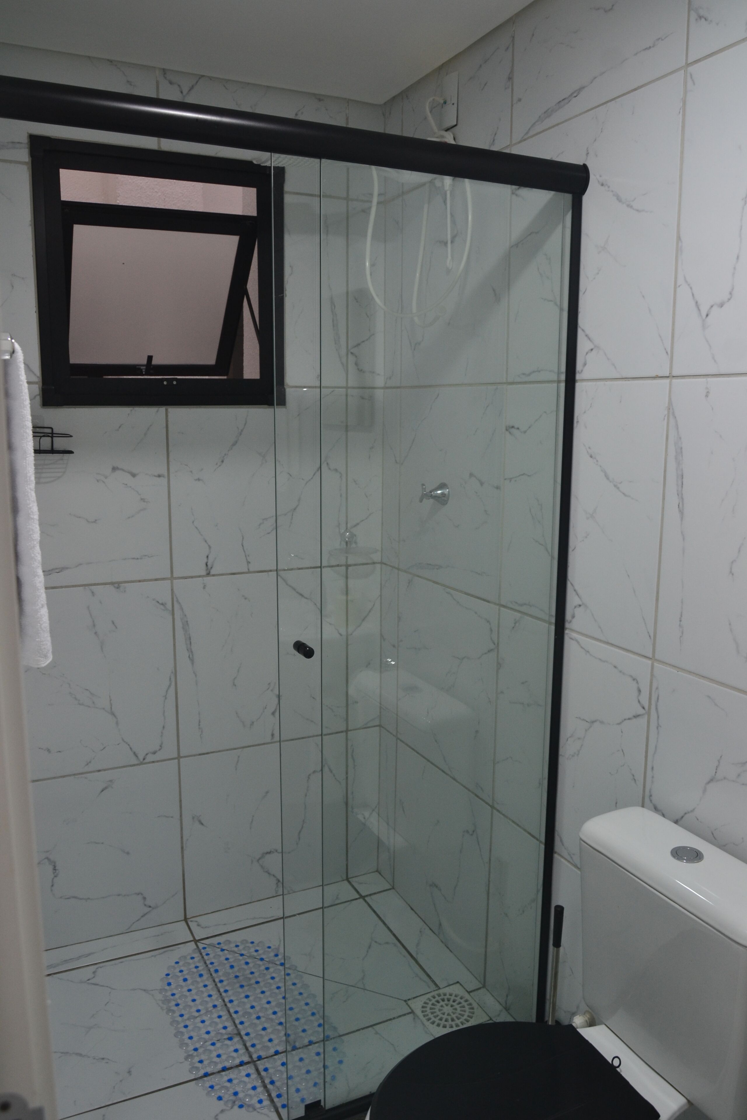 Ein Badezimmer mit Duschkabine, Toilette und Waschbecken.