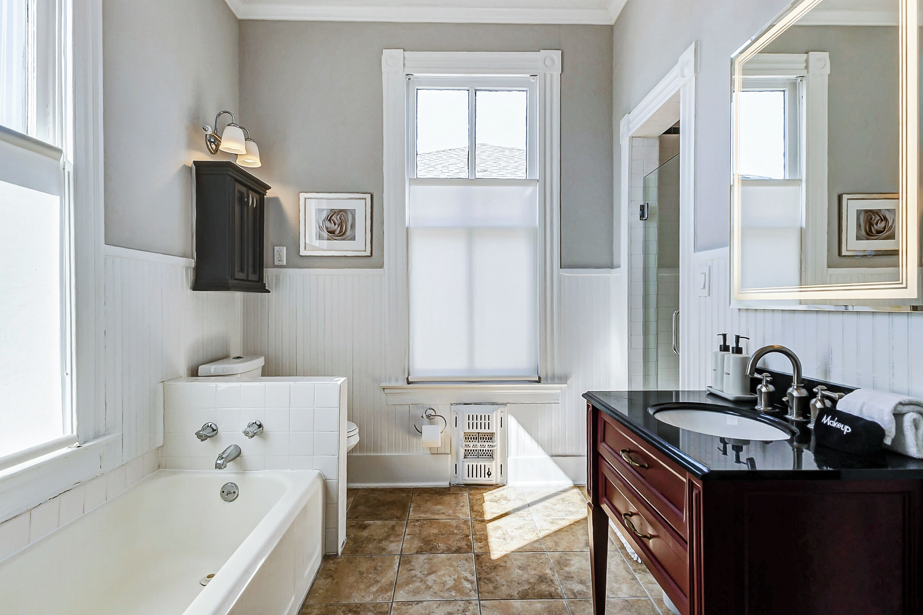 Une salle de bain avec une baignoire, un meuble-lavabo et un grand miroir.