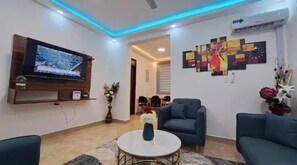 Relax in this stylish living room with a flat-screen TV, comfortable sofas, and a beautiful vase of flowers.