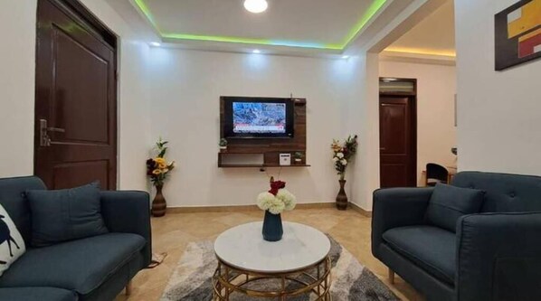 Relax in this inviting living area with a TV for entertainment, two sofas for seating, and a coffee table for socializing.