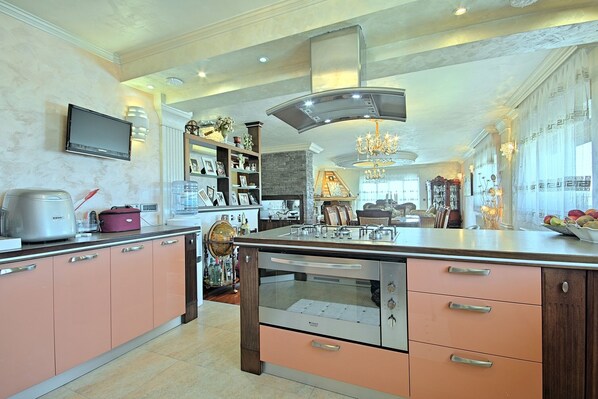A spacious kitchen with modern appliances, a built-in oven, and a large island with a sink.