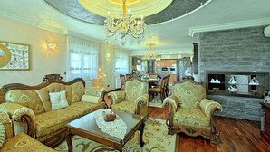 A luxurious living room with ornate furniture, a chandelier, and a stone fireplace. - Apartment Sani (Istria - Poreč) (Poreč)