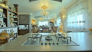 A spacious kitchen with a central island, built-in shelves, and a dining area in the background. - Apartment Sani (Istria - Poreč) (Poreč)