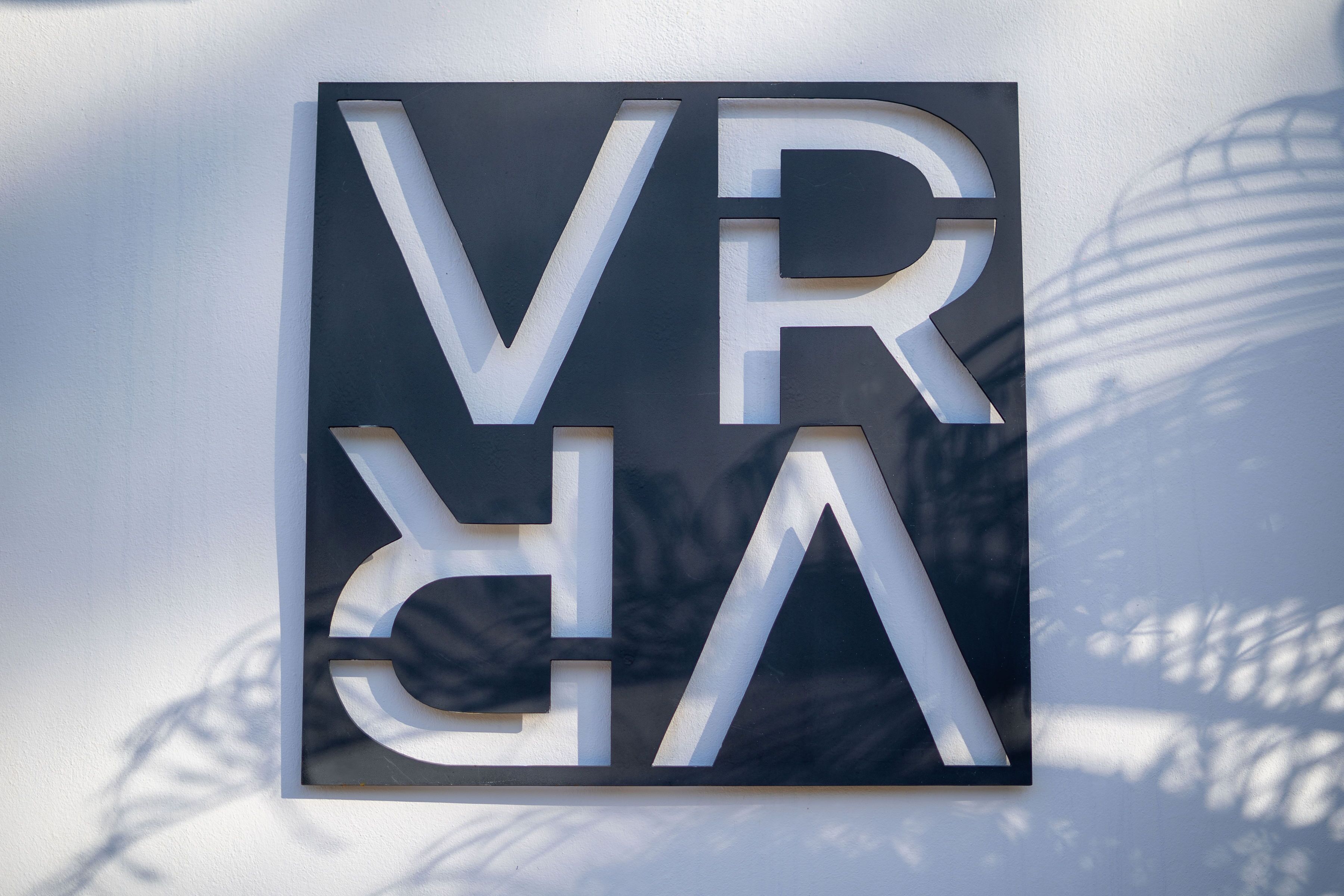 A sign with the letters "VR" in a modern, bold font.