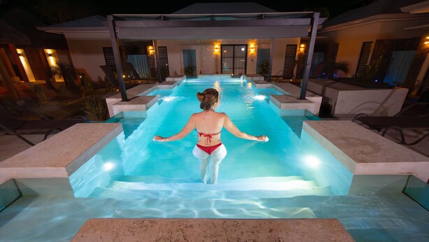 A swimming pool with steps leading into it, surrounded by lounge chairs and a covered area with seating. - Perfect Studio Kitchen Beautiful Pool Close to beach Avellanas AC PetFriendly (Guanacaste Province)