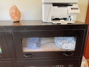 A black filing cabinet with a printer on top, a salt lamp, and a bed with a floral bedspread. - River Estate-Luxury Pool,  Spa (Anderson)