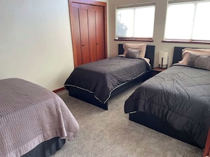 Ett sovrum med två sängar, en garderob och ett fönster.