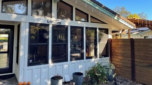 Un edificio con un cartel de 'Welcome', ventanas amplias y una valla de madera.