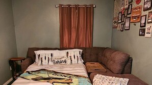 A bedroom with a bed, a ceiling fan, a green carpet, and a wall with framed pictures. - Private Home and Dock on Dunns Creek!
Sportsman's paradise, hosted by Sportsman. (Satsuma)