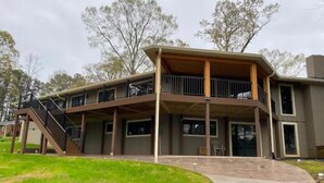 Un edificio de dos pisos con un patio cubierto y una escalera que lleva al nivel superior.