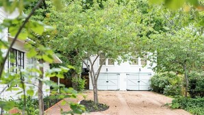 A residential driveway leading to a white garage with two doors. - Walkable to Fayetteville + Wine Bar | Sleeps 3 (Fayetteville)