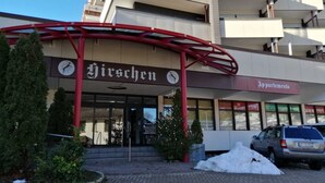 Un edificio con un letrero que dice "Hirschchen" y "Apartamentos", indicando un complejo residencial.