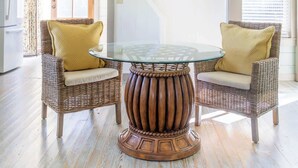 A dining area with wicker chairs, a glass table, and a wooden base. - Walk to Round Top Restaurants+Bars+Shops | Meme (Round Top)