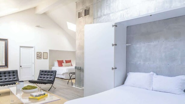 Une chambre moderne avec un grand lit, un coin salon doté d’une table basse et une vue sur l’intérieur de la pièce.
