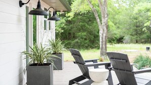 An outdoor patio with two Adirondack chairs, a table, and two potted plants. - Pool + 2 homes + Sleeps 10 | 6 Min. to Round Top (Round Top)