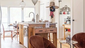 Una cocina amplia con armarios de madera, una isla central e iluminación colgante.
