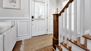 A staircase with white railings and wooden steps leading to a door with a window. - Wilmington's Heart, Pet-Friendly, Comfy Beds, Kids room! (Wilmington)