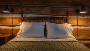 A bed with a wooden headboard, two bedside lamps, and a quilted bedspread. - Moore House Inn & Cabins (Marlinton)