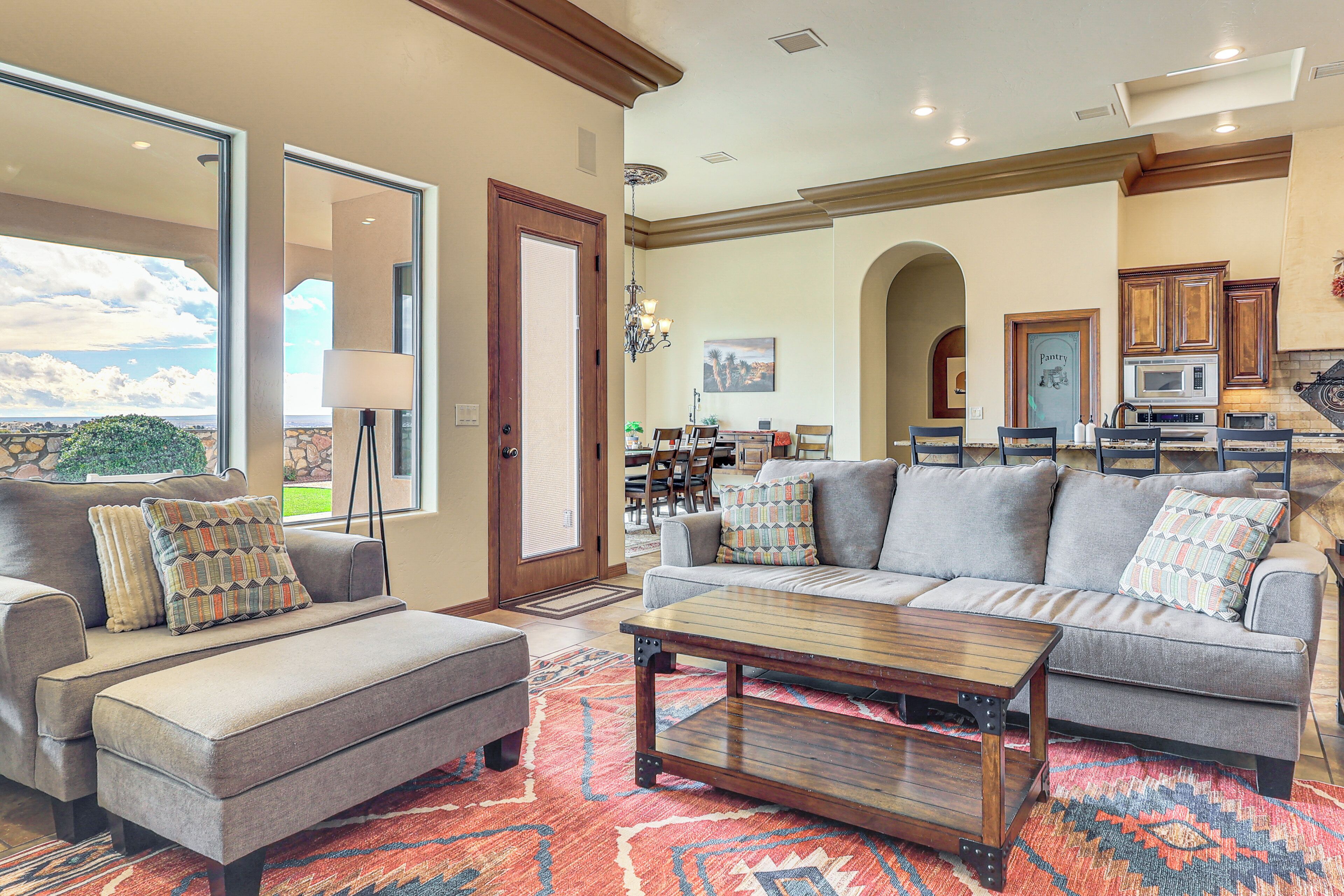 A spacious living room with a large sofa, a coffee table, and a patterned rug.