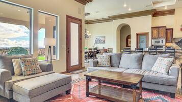 A spacious living room with a large sofa, a coffee table, and a patterned rug.