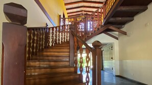 Eine hölzerne Treppe mit aufwendiger Geländerkonstruktion zu einer Empore.